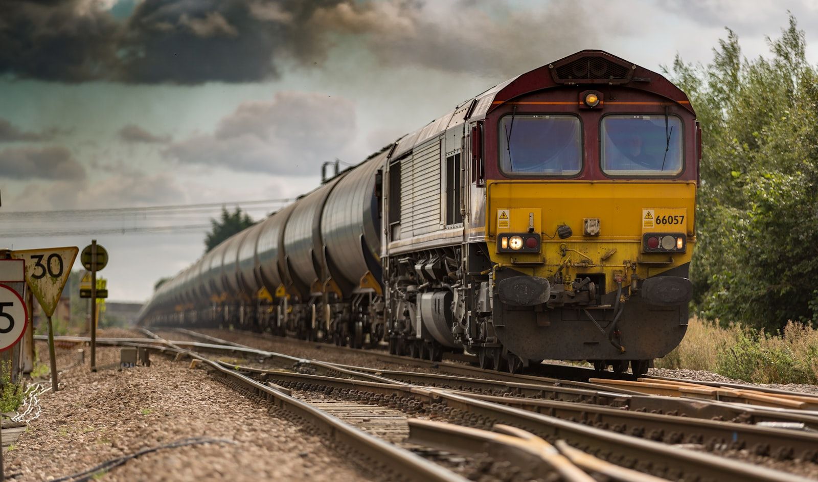 The interior of a quiet train station at night, long-exposure light trails from a departing train along the platform.